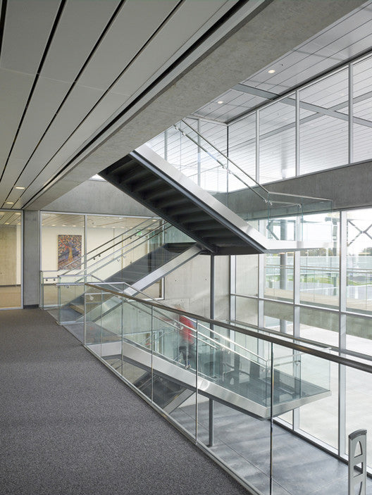 interior stairwell of modernist library building with picture hanging system on rear wall for art displays
