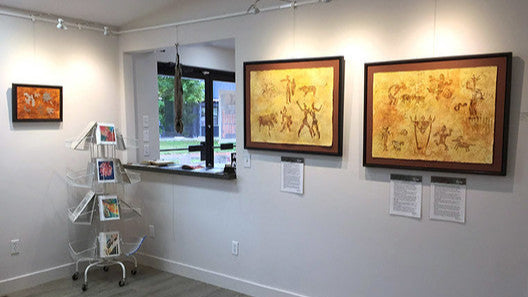 art gallery scene with wall-mounted art hangling system and integrated art lighting used to illuminate paintings
