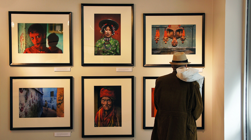 Group of six artworks arranged artfully on gallery wall