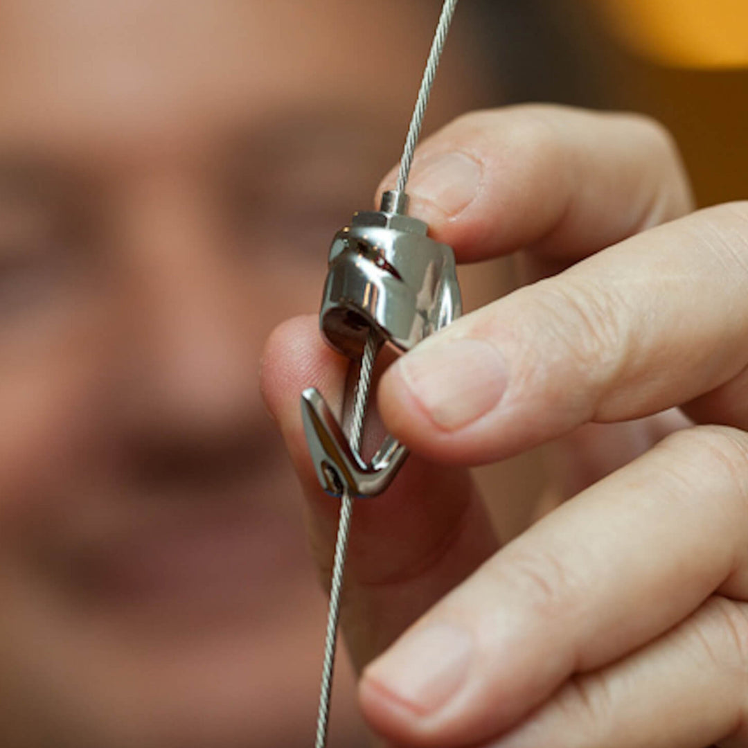 Close-up of a hand holding a metal fastener with a blurred background