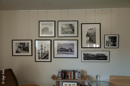 Gallery wall display of photographs hung neatly and stylishly using an art gallery hanging system by Gallery System