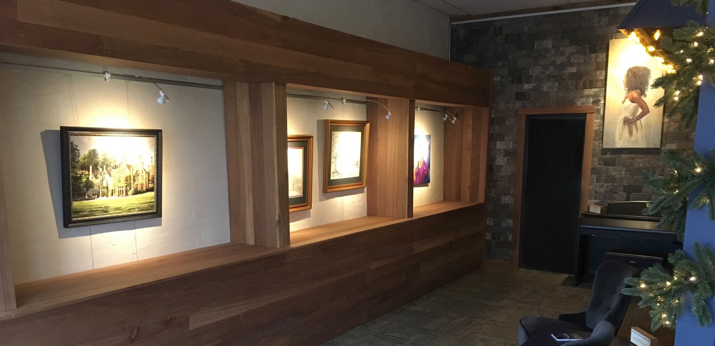paintings shown in wall alcoves on art gallery hanging system with integrated art lighting