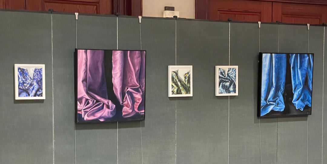 paintings shown on art hanging system mounted on partition wall
