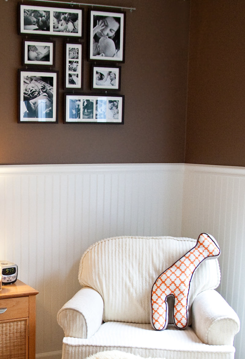 Gallery wall display of family photographs hung in a nursery room