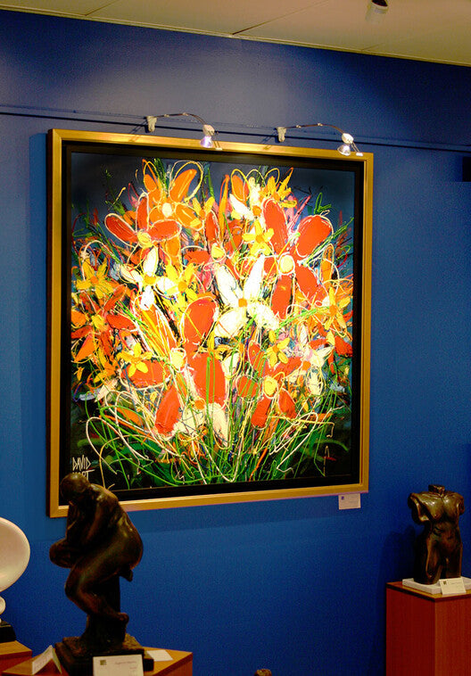 large somewhat abstract painting of flowers hung on blue wall of art gallery using a system for art display with integrated lighting