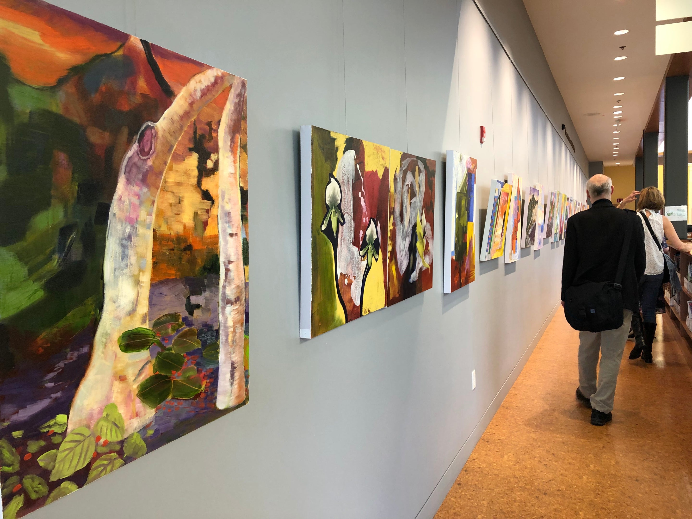 display wall at art gallery showing paintings hung using wall mounted picture hanging system