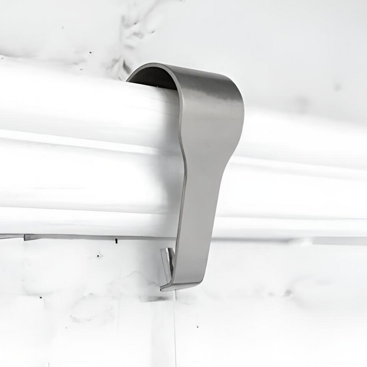 Stainless steel art hanging hook shown in use on white picture rail molding