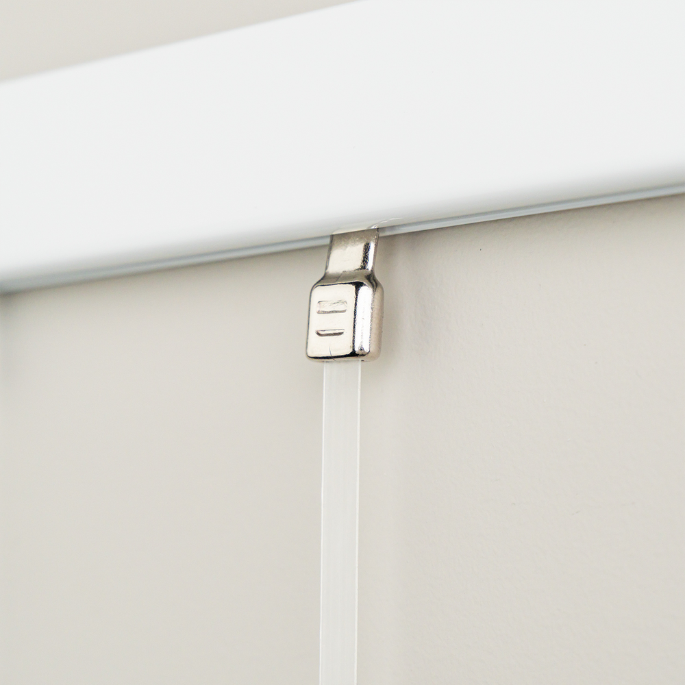 Closeup of GalleryOne Clear Tape picture hanging system showing hanger inserted into white wall track 