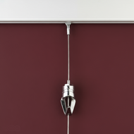 wall mounted picture hanging system closeup showing wall track, steel cable hanger, and pushbutton adjustable hanging hook