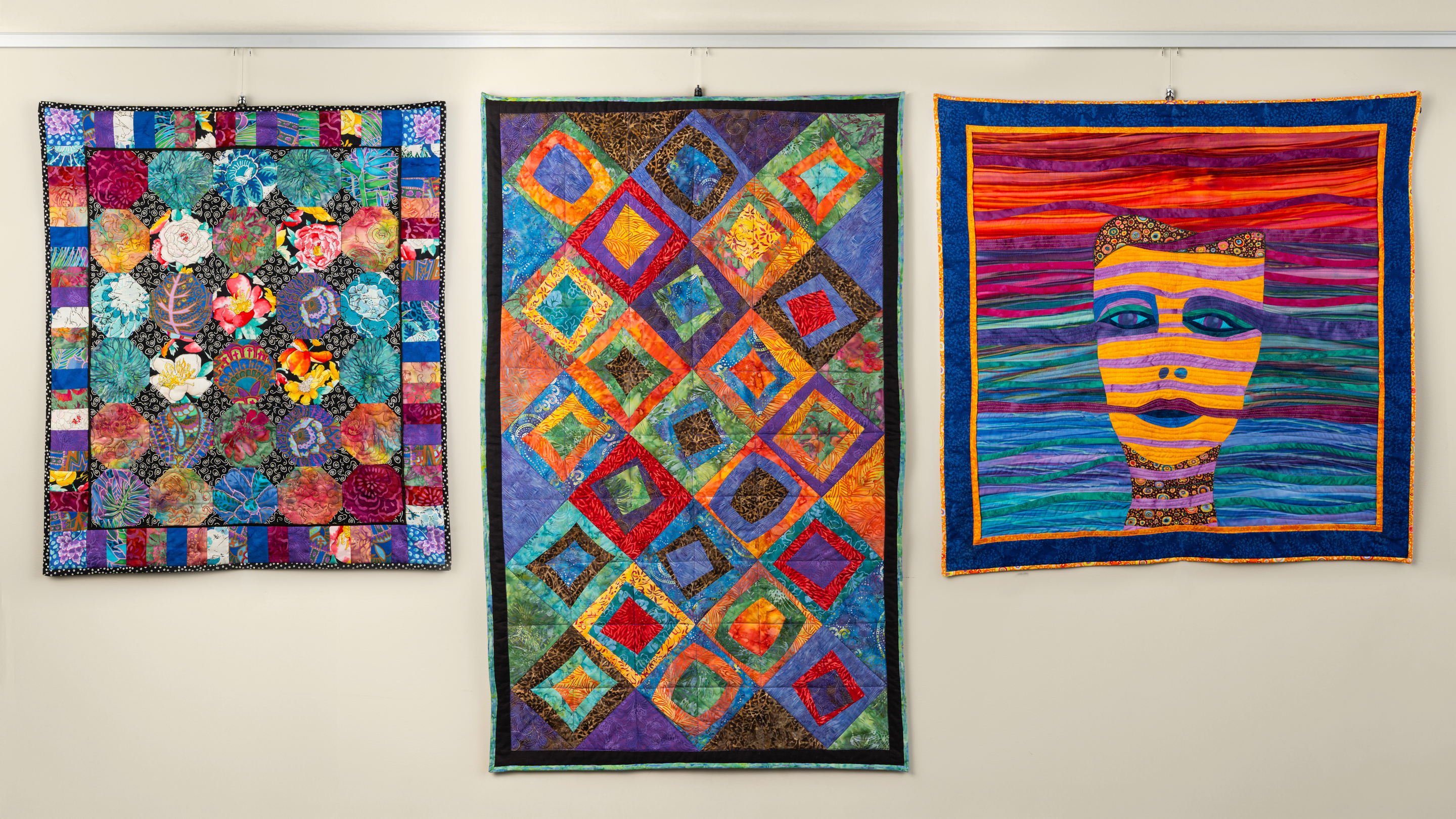 Quilts hanging on art hanging system