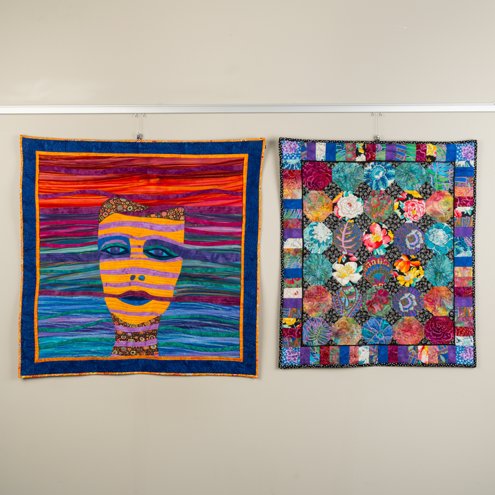Multiple quilts hanging on quilt hanging system