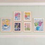 six still-life paintings hung in four columns using picture hanging system