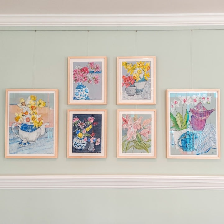 six still-life paintings hung in four columns using picture hanging system