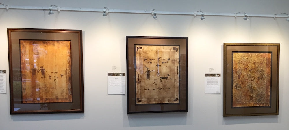 art gallery hanging system with integrated art lighting being used to display earthy abstract paintings