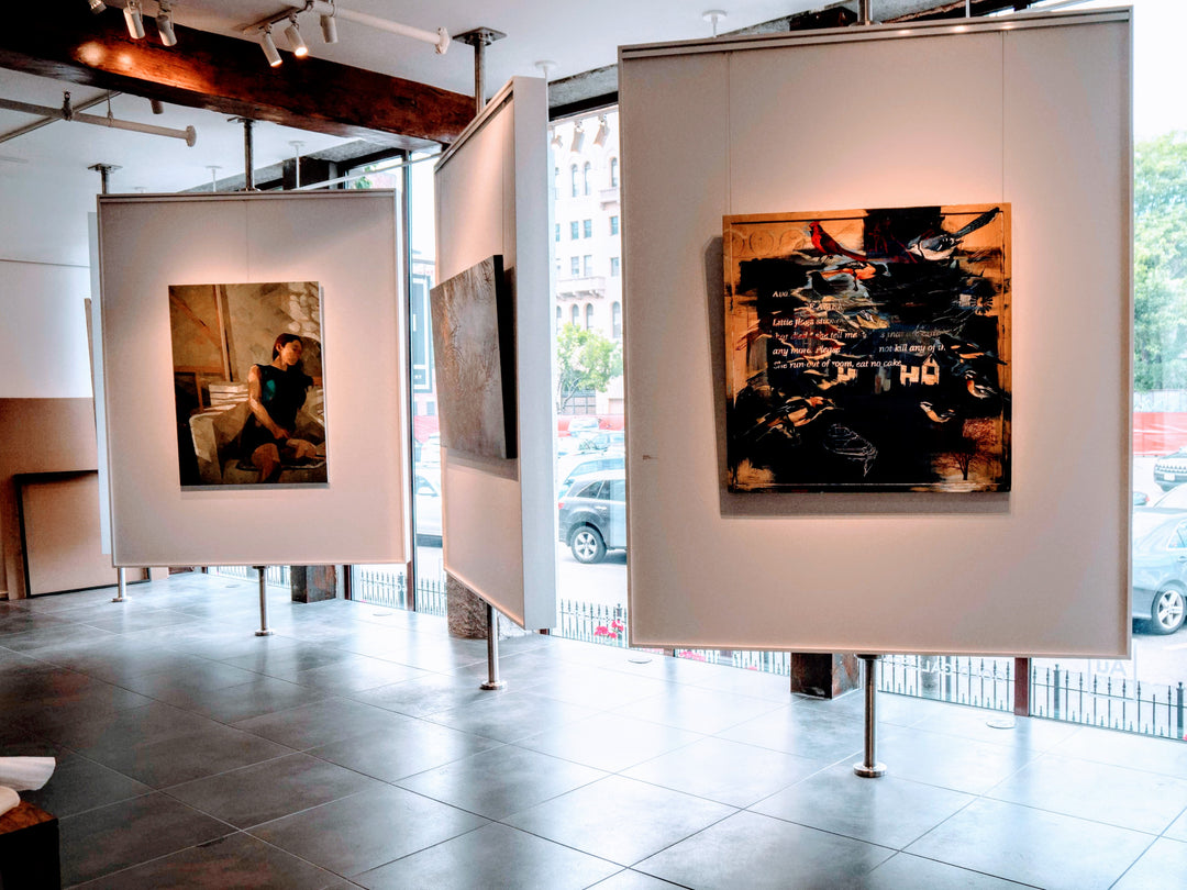 free-standing displays at art gallery showing paintings hung using short sections of art hanging system tracks and hangers