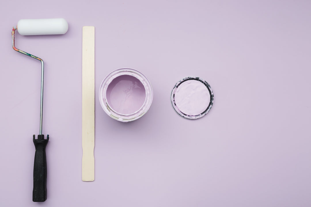 open can of purple paint along with stirring stick, lid, and paint roller 