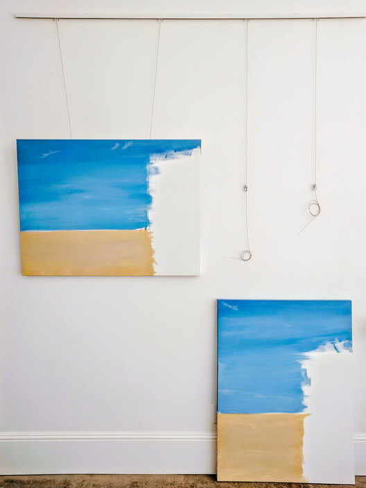 Paintings in art studio hung on picture hanging system