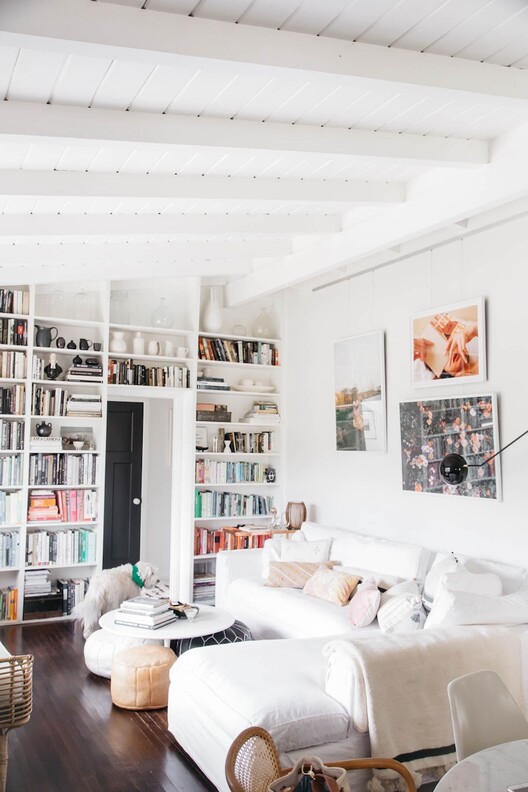 Rental loft apartment with picture hanging system on wall above sectional sofa